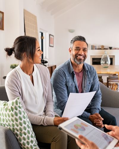 Two homeowners speaking with an insurance agent in their home