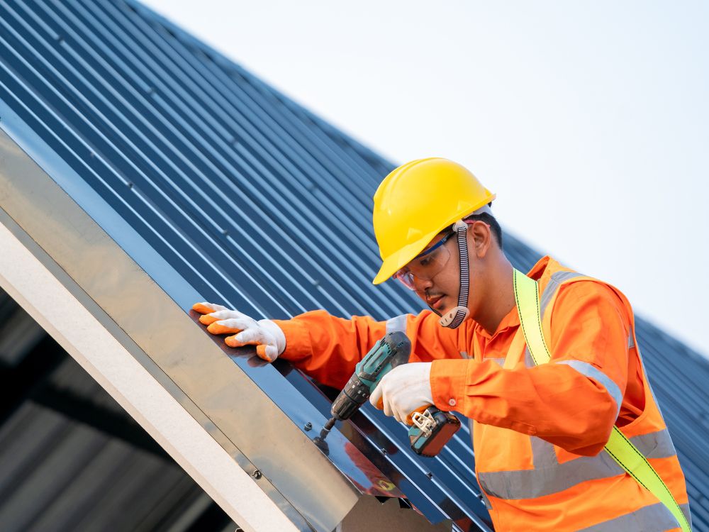 A roofer installing a metal roof