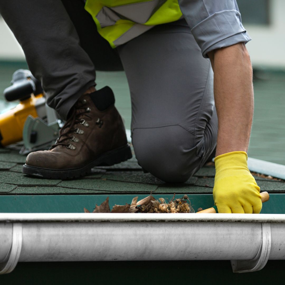 man cleaning out a gutter