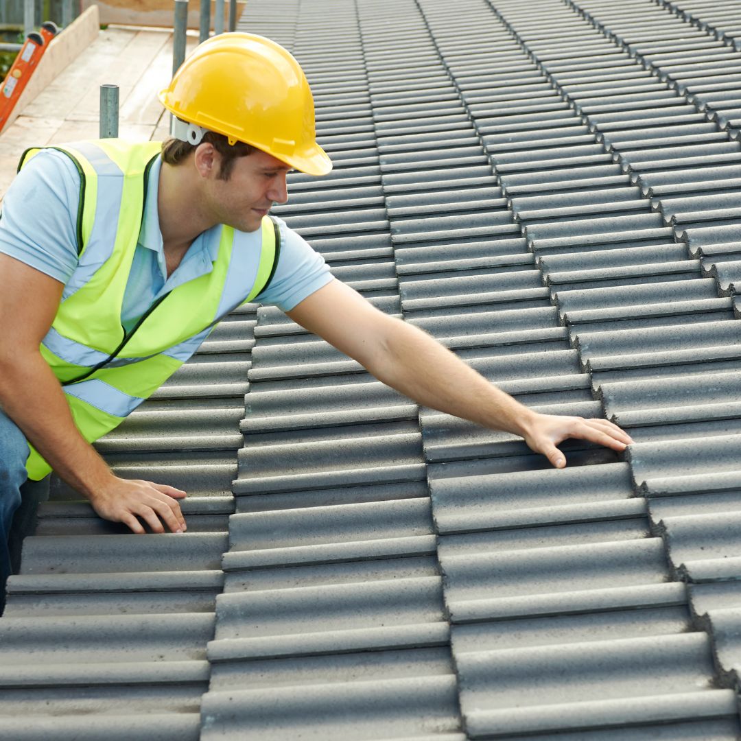 man checking roof shingles